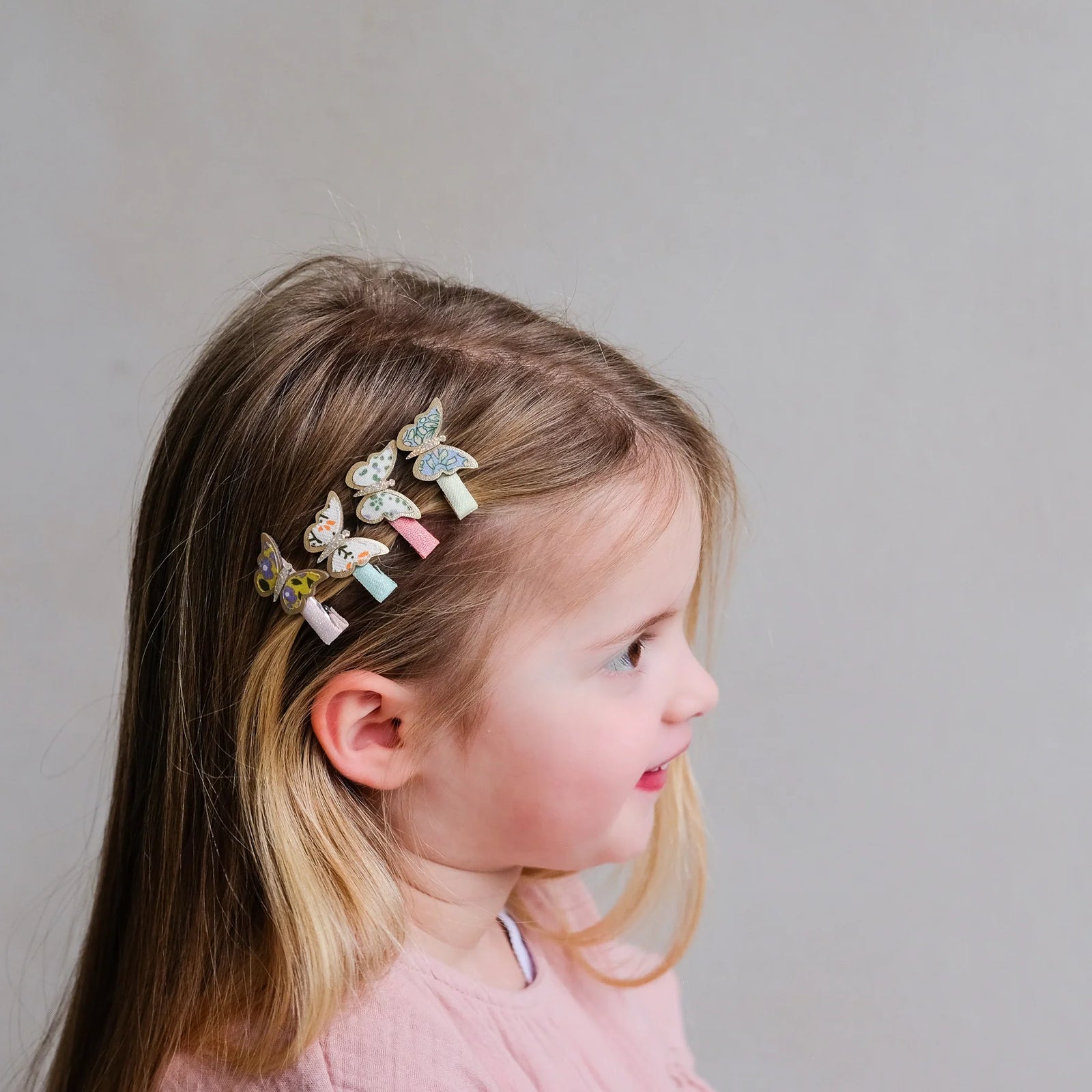 Set of butterfly-themed hair clips on colorful bands against a white background