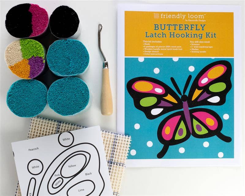 Butterfly latch hooking kit with yarn, needle, and pattern sheet on a white background