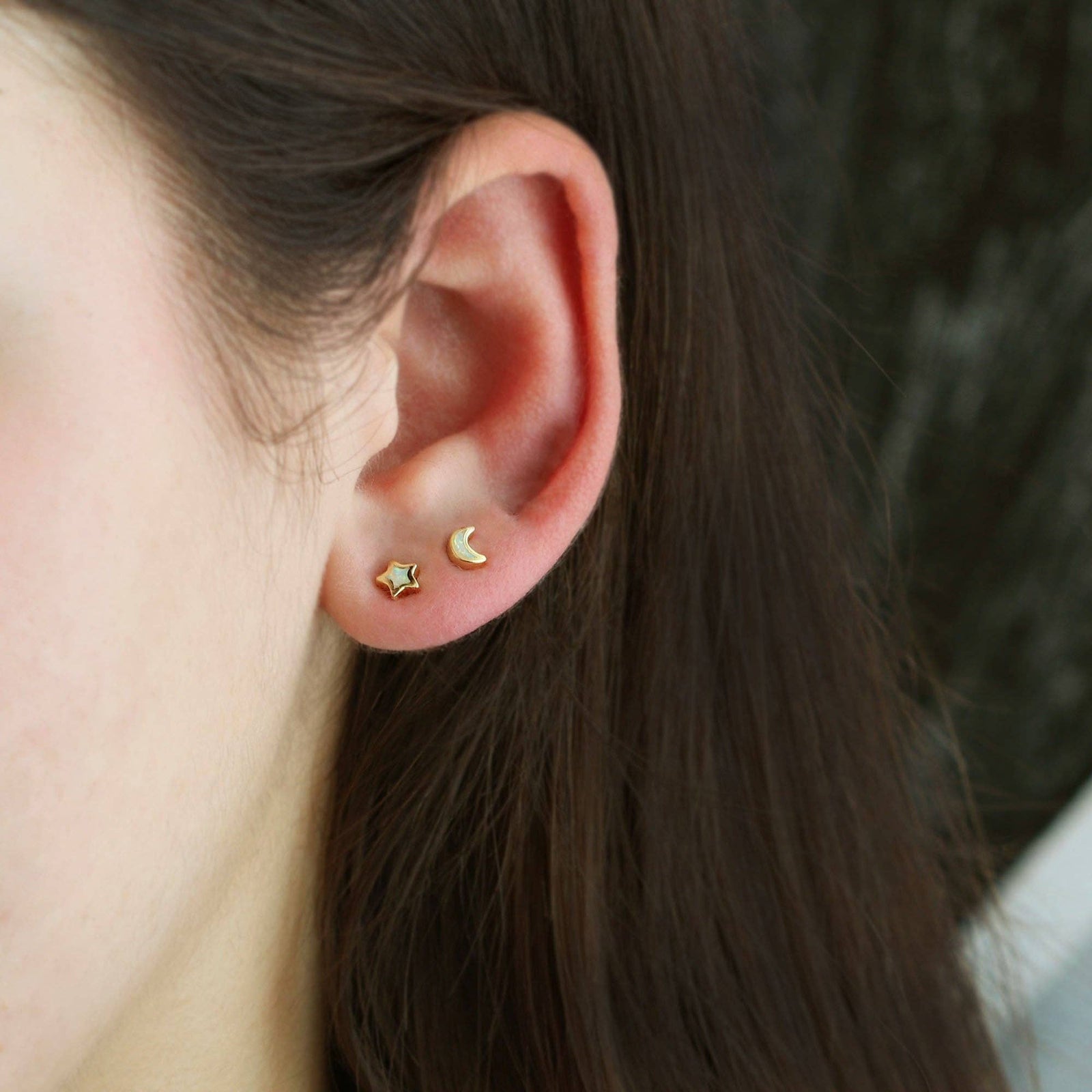 Gold star and moon earrings on a white background