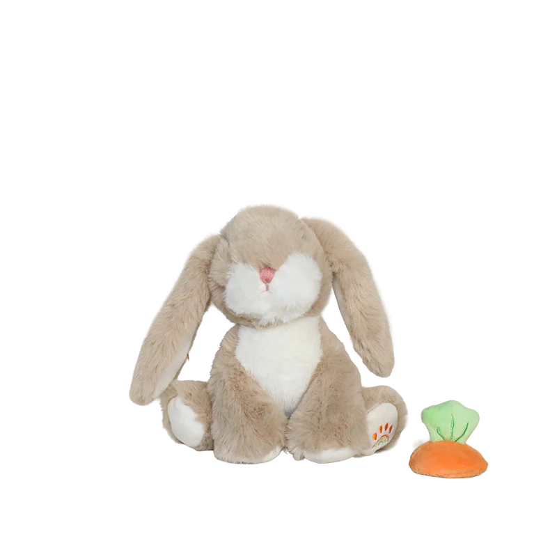 Child holding two plush bunnies against a plain background