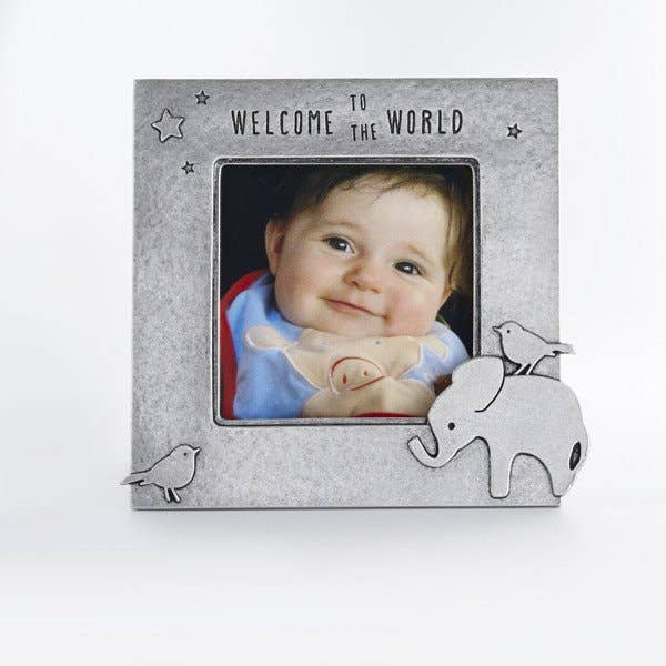 pewter elephab=nt picture frame next to wooden block